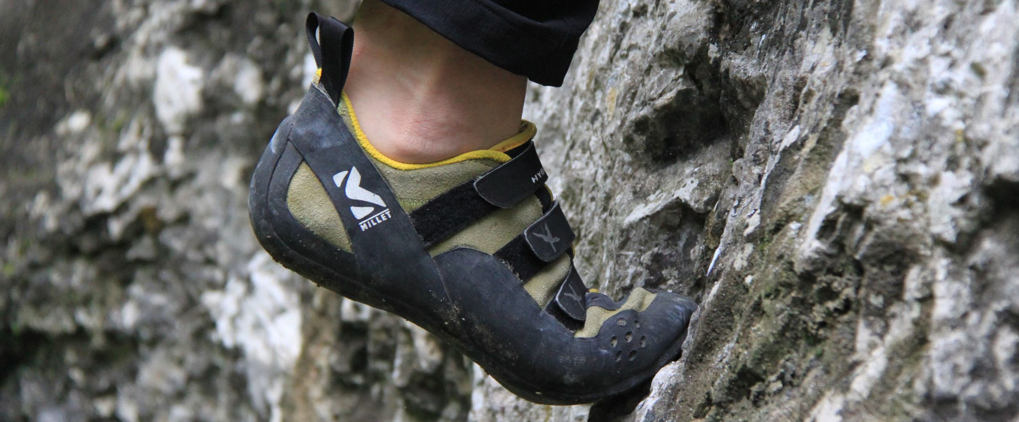 Fuß eines Kletterers mit Kletterschuh auf rauem Fels