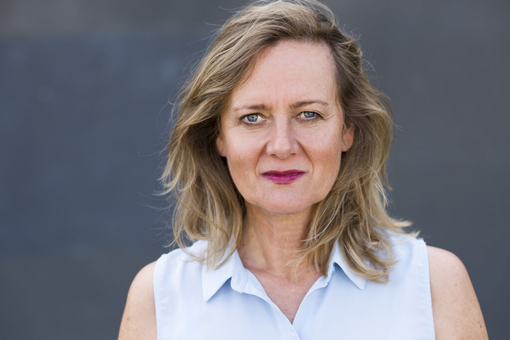 Portrait der Schauspielerin und Coreografin Monika Herzing mit blonden Haaren und blauen Augen