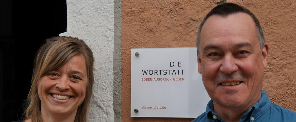Frank Martin Siefarth und Franziska Kucera mit dem Türschild der Medienagentur Die Wortstatt